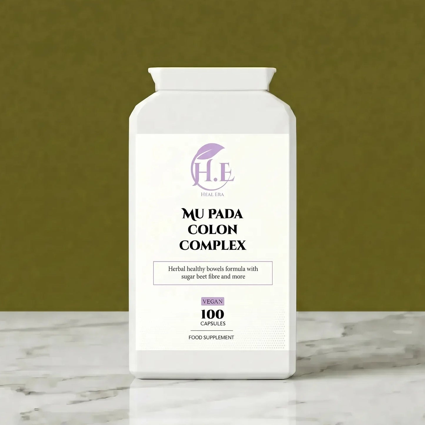 A white bottle of H.E Wellness Center Mu Pada Colon Complex dietary supplement, set on a white marble surface against a textured olive green background.