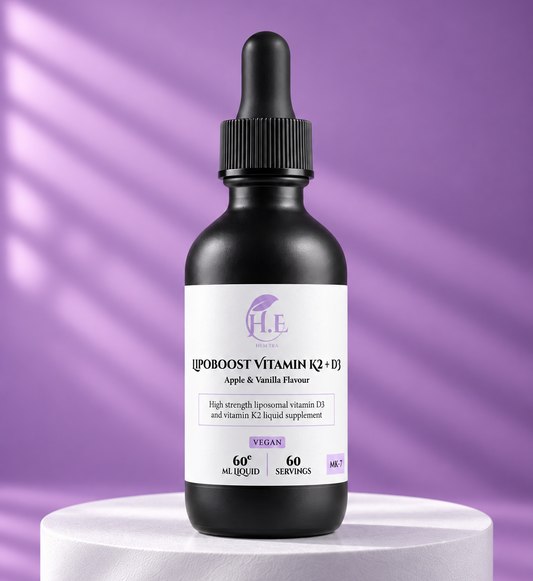 A black glass dropper bottle of H.E [IPOOOST VITAMIN K2 + E] liquid supplement, displayed on a white pedestal against a purple background with soft diagonal shadows.