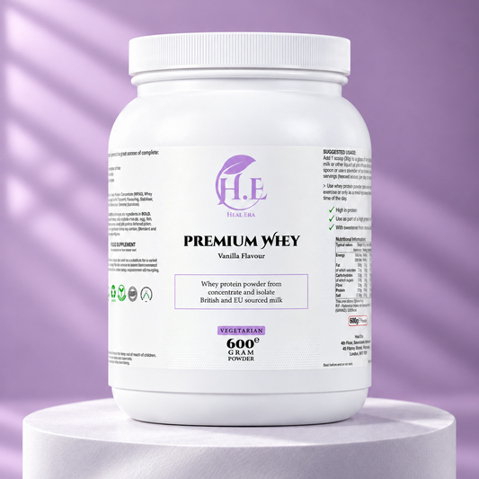 A white plastic tub of H.E Wellness Premium Whey Vanilla Flavour powder, displayed on a white cylindrical pedestal against a lavender-purple background with soft diagonal shadows.